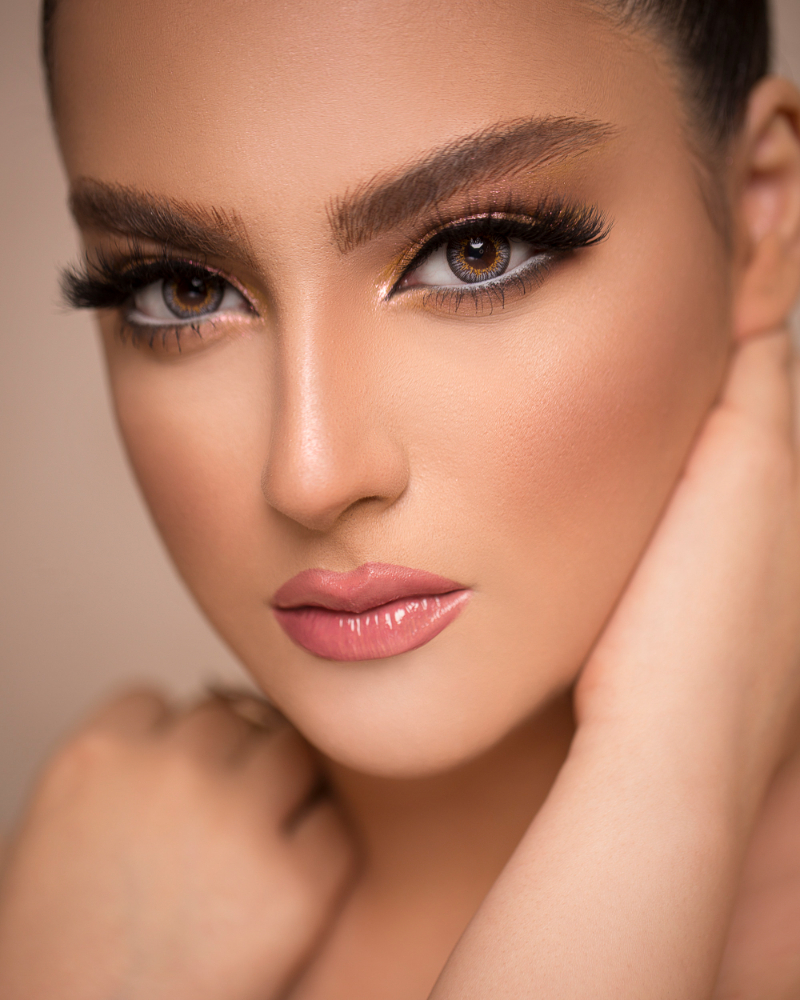 Maquiadora aplicando make profissional com pincéis premium no Glamour Beauty Studio